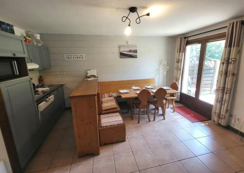 una cucina con tavolo in legno e una sala da pranzo di Cascades, 3 bedroom chalet with shared pool. a Samoëns