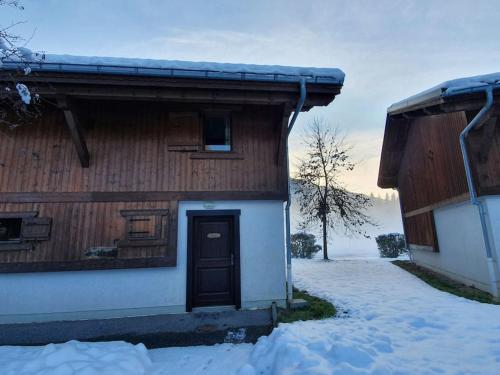 una casa in legno con una porta nella neve di Cascades, 3 bedroom chalet with shared pool. a Samoëns