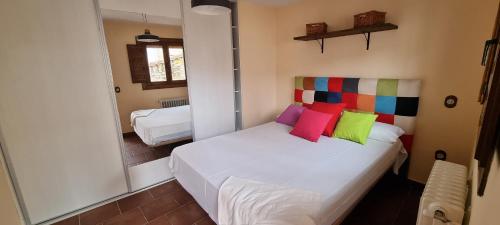 Un dormitorio con una cama con almohadas de colores. en Casa Rural de Lucía, en Horche