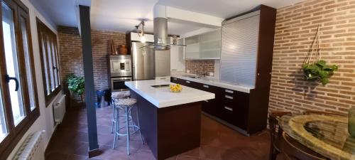 a kitchen with a white counter and a brick wall at Casa Rural de Lucía in Horche