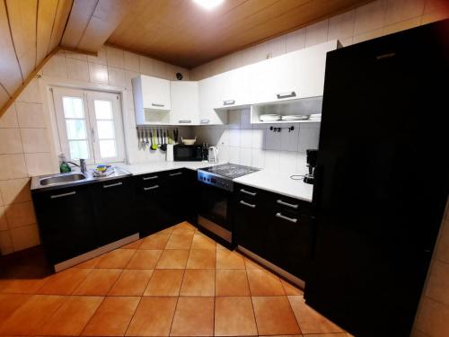 a kitchen with black and white appliances and a window at Ferienwohnungen Calwer Höfle City - für Firmen, Handwerker und Monteure in Calw