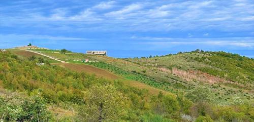 a green hill with a house on top of it at Duplex Seaview Condo in Durrës