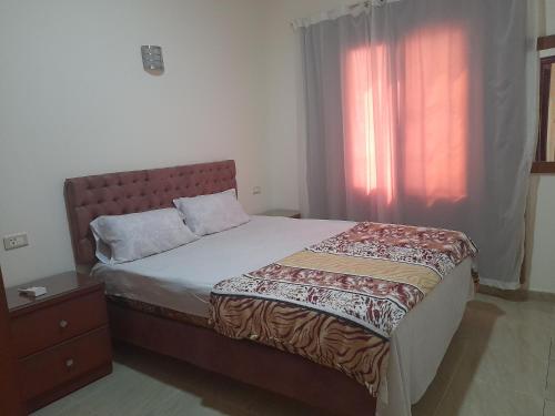a bed in a room with a window and a bed sidx sidx sidx at Hurghada Comfort Apartments in Hurghada