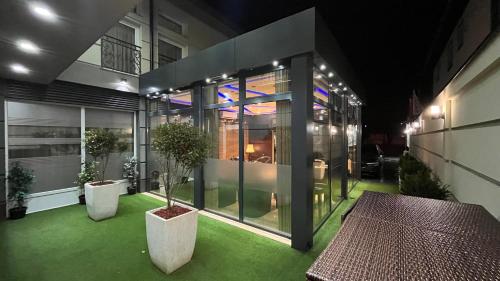 a house with a green yard with a table and plants at Hotel Morava - Šabac in Šabac