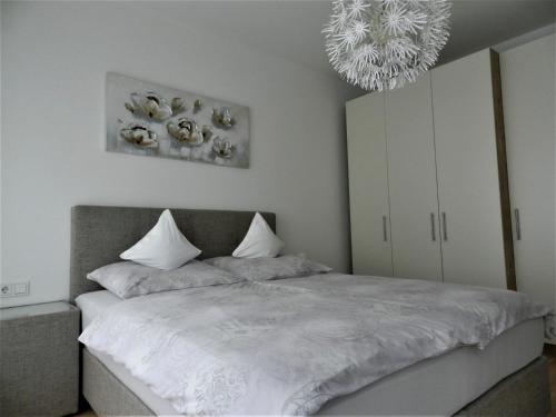 a bedroom with a bed and a chandelier at Ferienwohnung DANUBIA in Linz