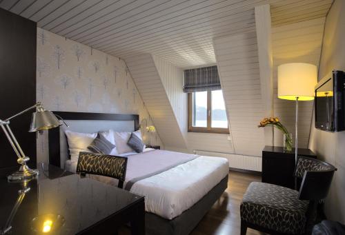 Pokój hotelowy z łóżkiem, biurkiem i stołem o wymiarach sześciu w obiekcie Rivage Hotel Restaurant Lutry w Lozannie