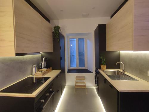 une cuisine avec deux lavabos et une fenêtre dans l'établissement Cocon Lux au centre de Voiron, à Voiron