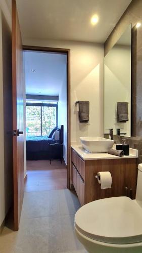 a bathroom with a sink and a toilet and a mirror at Acogedor y moderno departamento in Mexico City