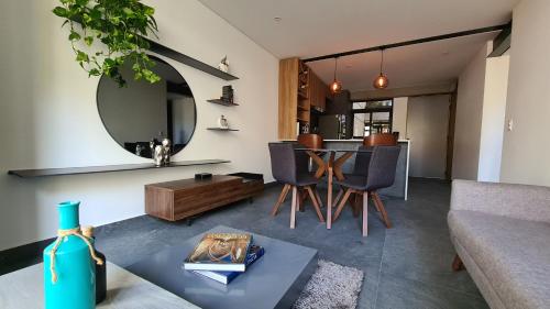 uma sala de estar com uma mesa e um sofá em Acogedor y moderno departamento em Cidade do México