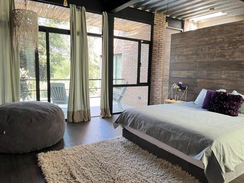 a bedroom with a large bed and a large window at Mi Refugio San Angel in Mexico City