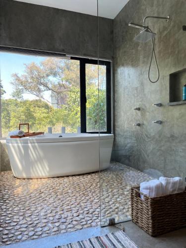 a bathroom with a tub and a large window at Mi Refugio San Angel in Mexico City