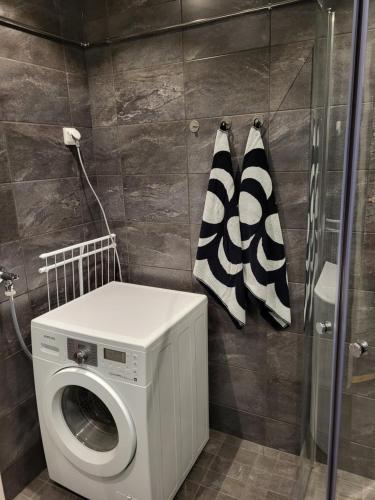 a laundry room with a washing machine and towels at Guest House Koskenkylä in Rovaniemi