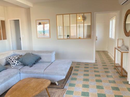 a living room with a couch and a table at Joli appartement avec vue mer in Narbonne