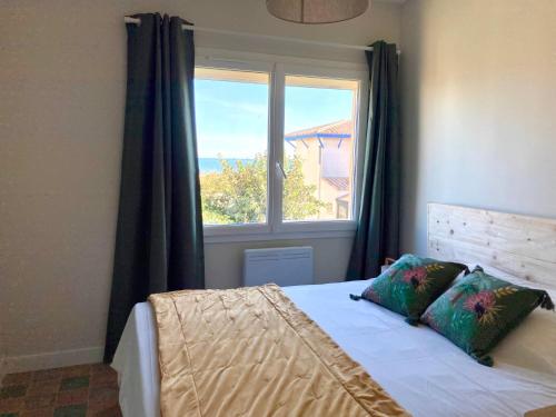 a bedroom with a bed with a large window at Joli appartement avec vue mer in Narbonne