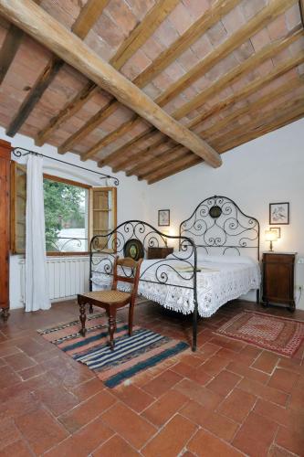 a bedroom with two beds and a chair and a window at Castello di Bibbione in San Casciano in Val di Pesa