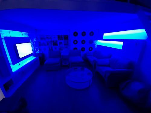 a blue room with a couch and a tv at 3 Separate Beds Central Apartment - 40m2 in Budapest