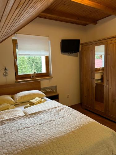 Un dormitorio con una cama grande y una ventana en Guest House Alpha Ski Camp, en Jahorina