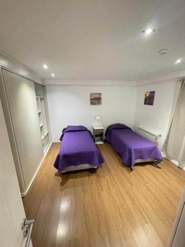 2 Betten in einem Zimmer mit lila Bettwäsche in der Unterkunft Entire apartment in Patagonia rebate in physical dollar in Ushuaia