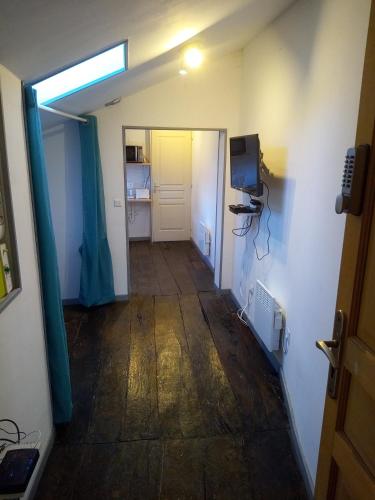 a room with a hallway with a television and a door at Studio tout équipé plein centre-ville de Limoges in Limoges