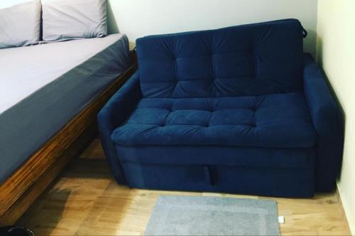 a blue couch in a bedroom with a bed at Loft/kit estilo industrial encantador c/garagem pv in Belém