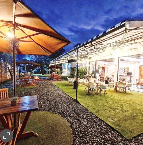 an outdoor patio with tables and chairs and umbrellas at Casa Hotel Bremen in Circasia