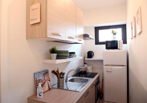 a small kitchen with a sink and a refrigerator at Lucca 22 in Milan