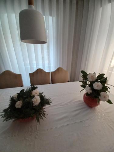 a table with two vases with flowers on it at O 21 da Vila in Seia