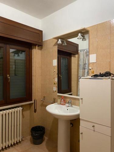 bagno con lavandino e frigorifero bianco di Casa Andrea a Ghedi