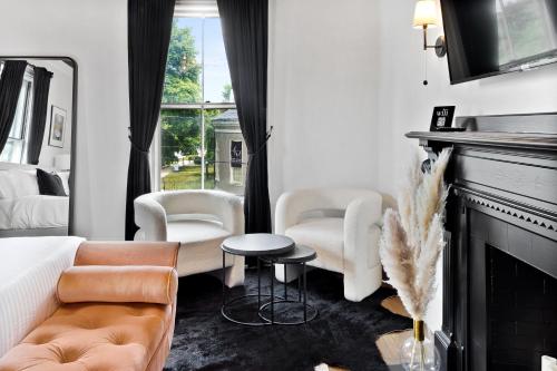 a living room with a couch and chairs and a fireplace at The Coach House in Salem