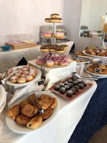 a table filled with different types of pastries and desserts at Hotel Ravello Adults Only in Rimini