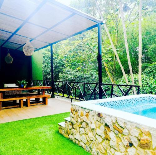 a patio with a pool and a bench and grass at Casa Hotel Bremen in Circasia
