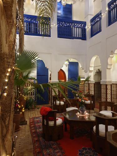 un restaurante con paredes azules y blancas, mesa y sillas en Riad Dar Colline, en Marrakech