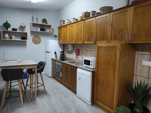 eine Küche mit Holzschränken und einem weißen Kühlschrank in der Unterkunft Casa da Guida in Angra do Heroísmo