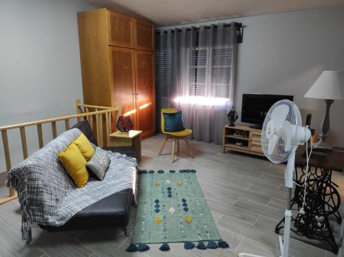 a living room with a couch and a fan at Casa da Guida in Angra do Heroísmo