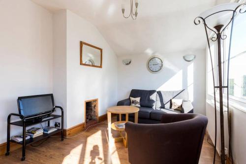 a living room with a couch and a tv at The Apartment on Granville in Sevenoaks