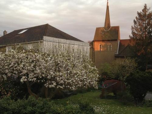 a church with a flowering tree in front of a building at The Apartment on Granville in Sevenoaks