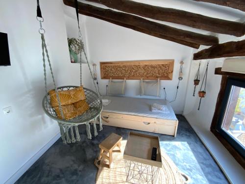 a bedroom with a swinging bed and a table at El mirador de Pi in Alcalá del Júcar