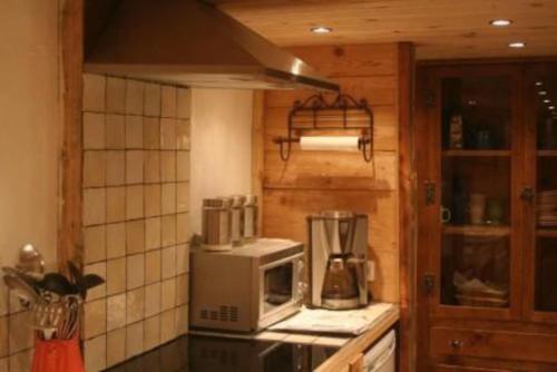 a kitchen with a stove with a microwave and a counter at Three Bedroomed Chalet Apartment in Chamonix-Mont-Blanc
