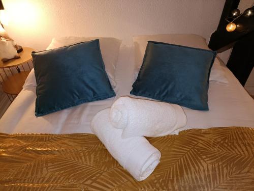 - un lit avec 2 oreillers et des serviettes dans l'établissement Le cœur du centre historique refait à neuf, à Honfleur