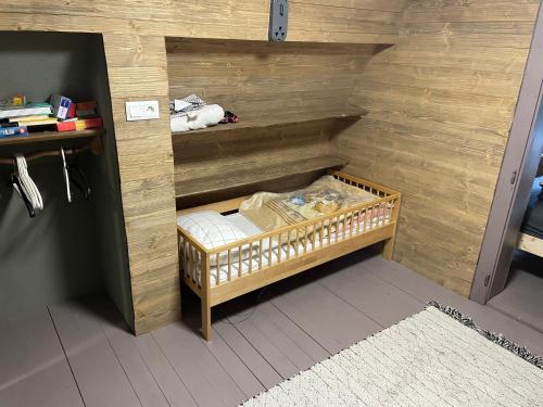 ein kleines Zimmer mit einem Kinderbett an einer Holzwand in der Unterkunft Chalet FiMiLi in Vyšná Boca