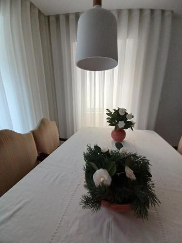 a table with a flower arrangement on it with a lamp at O 21 da Vila in Seia