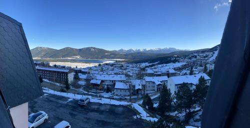 una vista aérea de una ciudad con edificios cubiertos de nieve en Studio avec loggia Les Angles - Superbe vue sur Lac et Montagnes en Les Angles
