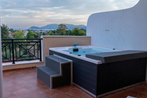 a hot tub sitting on top of a balcony at Anagenessis Resort in Kalamaki