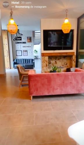 a living room with a red couch and a tv at Casa Hotel Bremen in Circasia