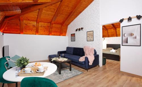 un soggiorno con un divano blu e un tavolo di One Love Central Cottage a Bucarest