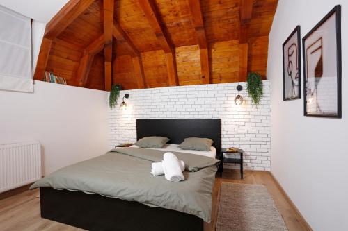 a bedroom with a large bed in a brick wall at One Love Central Cottage in Bucharest