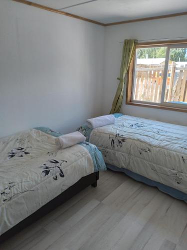 2 camas en una habitación con ventana en Antawara, en Chile Chico