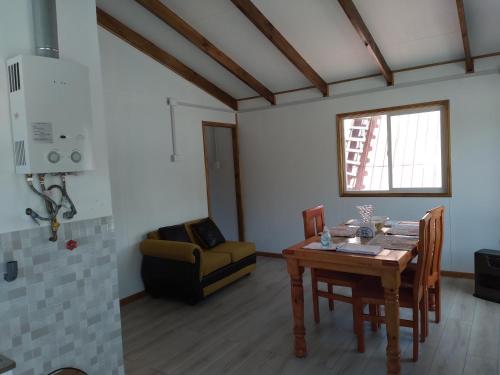 a dining room with a table and a couch at Calfu in Chile Chico