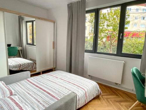 a bedroom with a bed and a large window at FLH - Nana's apartment in Sibiu