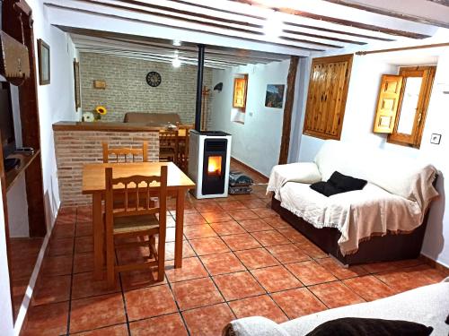 sala de estar con sofá, mesa y chimenea en Cortijo Ramon Petra, en Nerpio